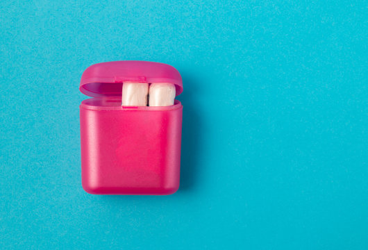 Feminine hygiene tampons in a pink box for delivery and storage on a blue background. The concept of feminine hygiene during menstruation, on critical days. Flat lay, top view