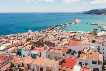 Fototapeta na wymiar Peniscola port, view from castle Papa Luna, landmark of the city. Turquoise bay of Mediterranean Sea, bright, colours, sunny day. Popular travel destinations, touristic place. Spain