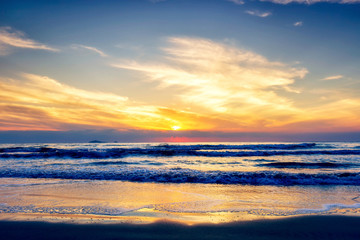 Naklejka na ściany i meble Scenic view of sand beach at the sea in morning sunrise sky.