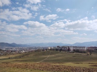 Fototapeta premium Sunrise and sunset, beautiful clouds over the meadow, hills and buildings in the town. Slovakia