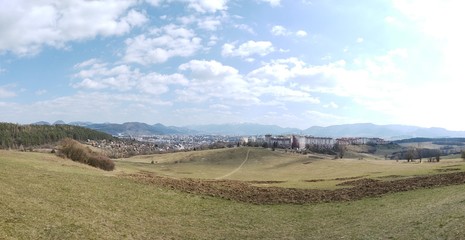 Obraz premium Sunrise and sunset, beautiful clouds over the meadow, hills and buildings in the town. Slovakia