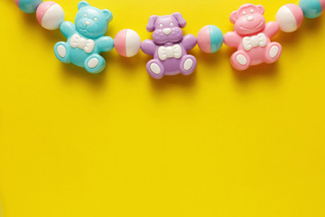 Colorful and various plastic toys for babies on a yellow background. Layout. Empty space for the text. Minimalism