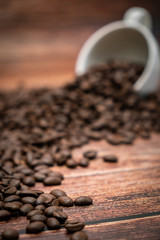 Coffee beans pouring from coffee cup