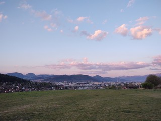 Sunrise and sunset, beautiful clouds over the meadow, hills and buildings in the town. Slovakia