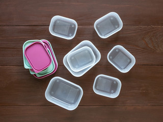 Plastic containers for transportation and storage food products laid out on a wooden table