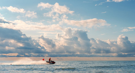 The water rescuer patrols sea shore on a jet ski