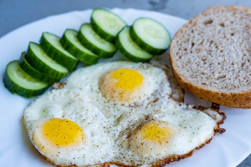 Close up of fried eggs vegetables and bread
