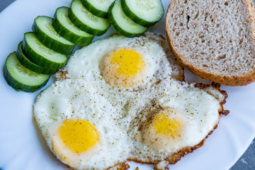 Close up of fried eggs vegetables and bread