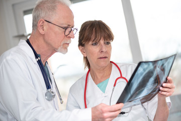 Two doctors examining x-ray report