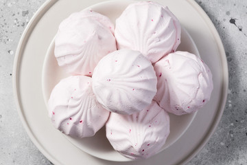Pink marshmallows on a white plate. The view from the top. Closeup