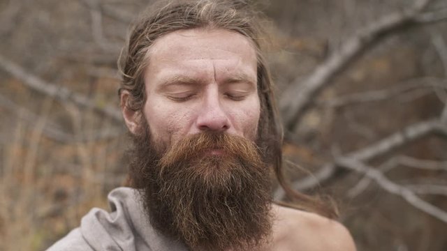 Bearded yogi meditates with closed eyes