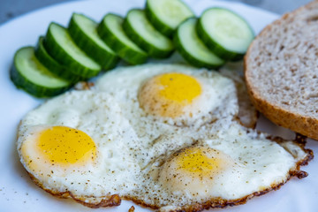 Close up of fried eggs vegetables and bread	