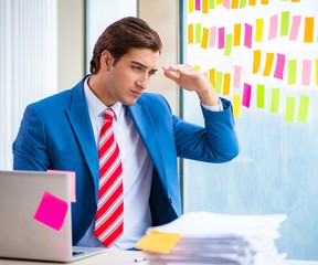 Young handsome employee with many conflicting priorities