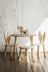 Photo of a wooden dog on wheels of beech on table.A toy for entertaining children and resting parents