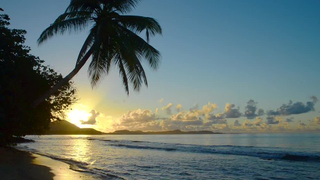 soleil levant derrière coline devant une crique de la martinique dans les Antilles