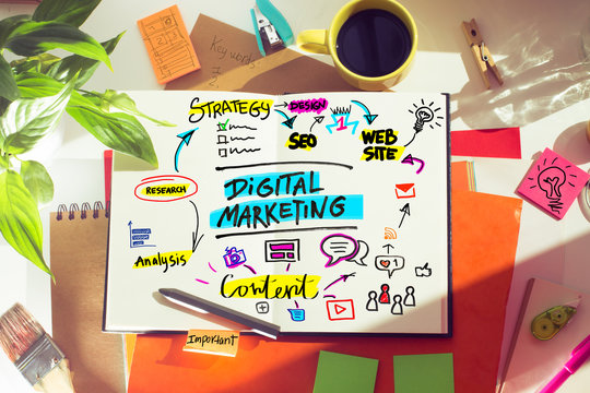 Lay out on desk with illustration on note book about digital marketig