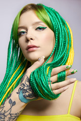 Portrait of a woman with creatively colored hair in green and yellow color. Colorful bright...