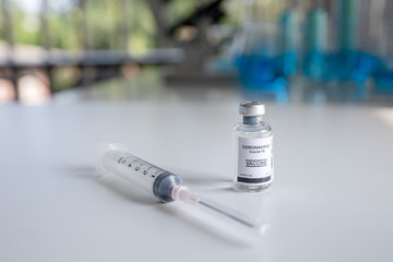 Close-up on Laboratory Tube Virus corona covid 19 vaccine. Scientist research for new novel corona virus immunization drug concept. Coronavirus COVID-19 vaccine vial and injection syringe.