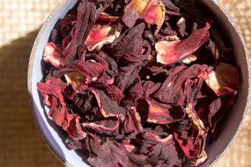 Top view of a cup with dried hibiscus flowers for a herbal infusion
