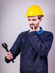 a young man for the first time holding an adjustable wrench