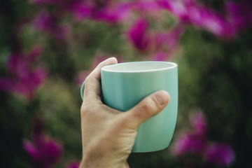 cup in hand on magnolia background
