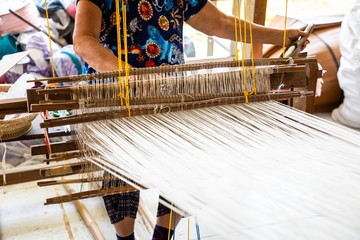 handicraft cotton or silk weaving on wooden loom , occupation of villagers at workplace in rural ....