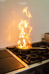 Pan on fire in kitchen presenting fire hazard © Asja Zec