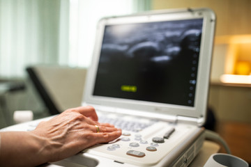 Fototapeta na wymiar Close up shot of technician operating an ultrasound machine at a clinic. 