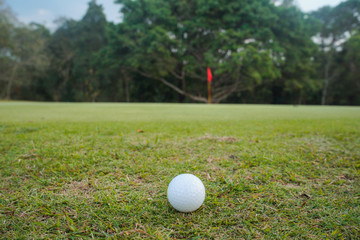 Golf ball on tee in beautiful golf course
