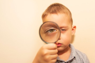 a child looks through a magnifying glass