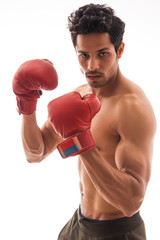 Man wearing boxing gloves and standing in front of a white background. 
