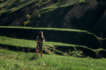 beautiful emotional girl on green saturated hills