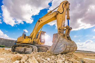 Excavator in a quarry extracting stone
