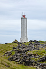 Fototapeta na wymiar Rocket-shaped lighthouse surrounded by volcanic rocks