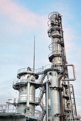 Oil refinery chemical plant vertical bottom view with copy space over evening sky background.