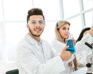Fototapeta premium man scientist holding a flask of liquid for the experiment