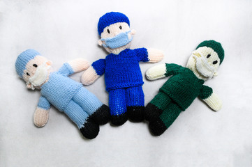 3 knitted front line workers on white background. covid 19