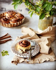 Cinnamon buns in a plate on a gray background, still life