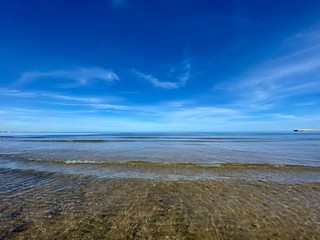 The cleanest sea on a city beach in Valencia, Spain. Clear water and blue sky. Сoastline
