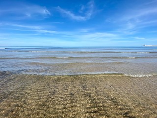 The cleanest sea on a city beach in Valencia, Spain. Clear water and blue sky. Сoastline