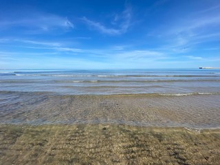 The cleanest sea on a city beach in Valencia, Spain. Clear water and blue sky. Сoastline