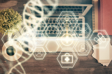 DNA hologram drawings over computer on the desktop background. Top view. Multi exposure. Concept medical education.