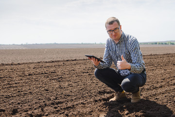 farmer sitting in a plowed field. Agriculture, crop concept.