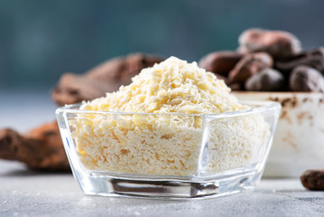 Organic cocoa butter, cocoa beans, grated cocoa lump, dark chocolate on gray blue background. Copy space