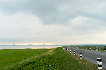 road near lagoon with green grass
