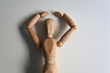 Muñeco de madera de cintura para arriba con los brazos levantados. Pensativo, sorprendido, bailando.