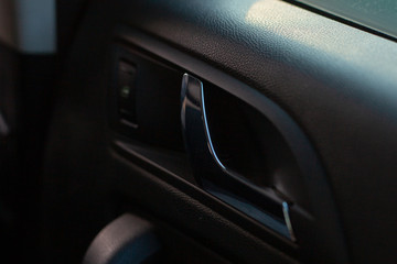 Close up detail of a car interior - part of the car door with the opening handle