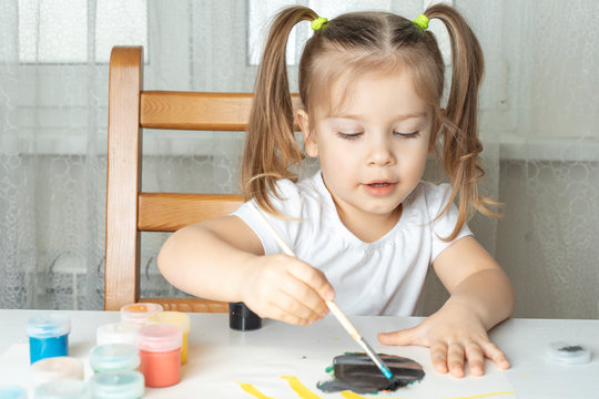what to do for a child during the period of quarantine and self-isolation, a girl plays and paints with gouache
