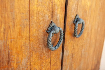 Old wooden door from medieval era with a old door knob for print.