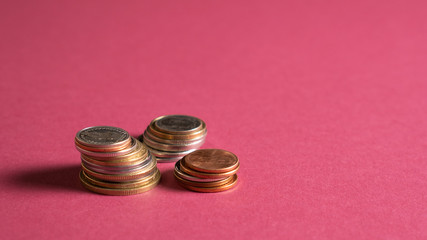 Stack of different size coins isolated on bright background. Money saving financial concept. Economic crisis